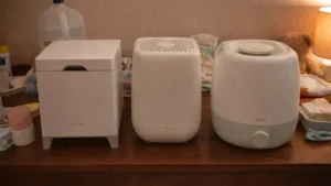 The three best cool mist humidifiers for baby congestion—Carepod Cube Plus X50V, Canopy Bedside Humidifier 2.0, and Frida Baby 3-in-1—on a nursery dresser.