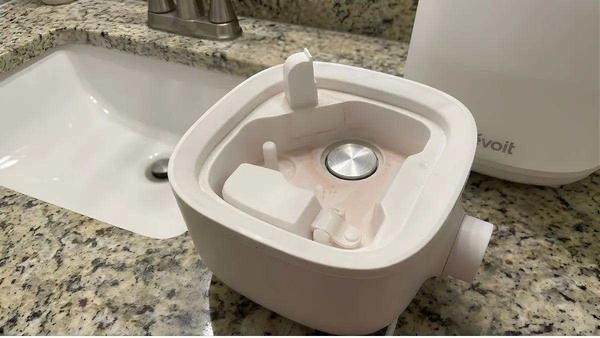 Close up of pink slime and mold inside the base of an uncleaned humidifier